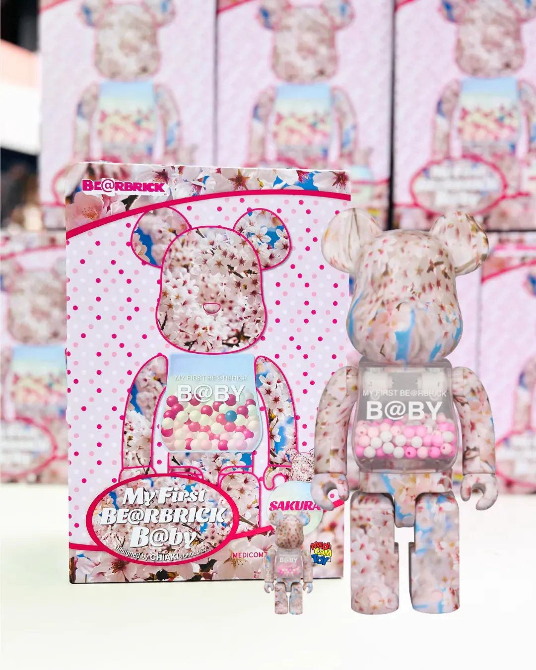 Set aus zwei My First Be@rbrick B@by Sakura Ver. Figuren in den Größen 100% und 400% mit einem rosa Blumenmuster.