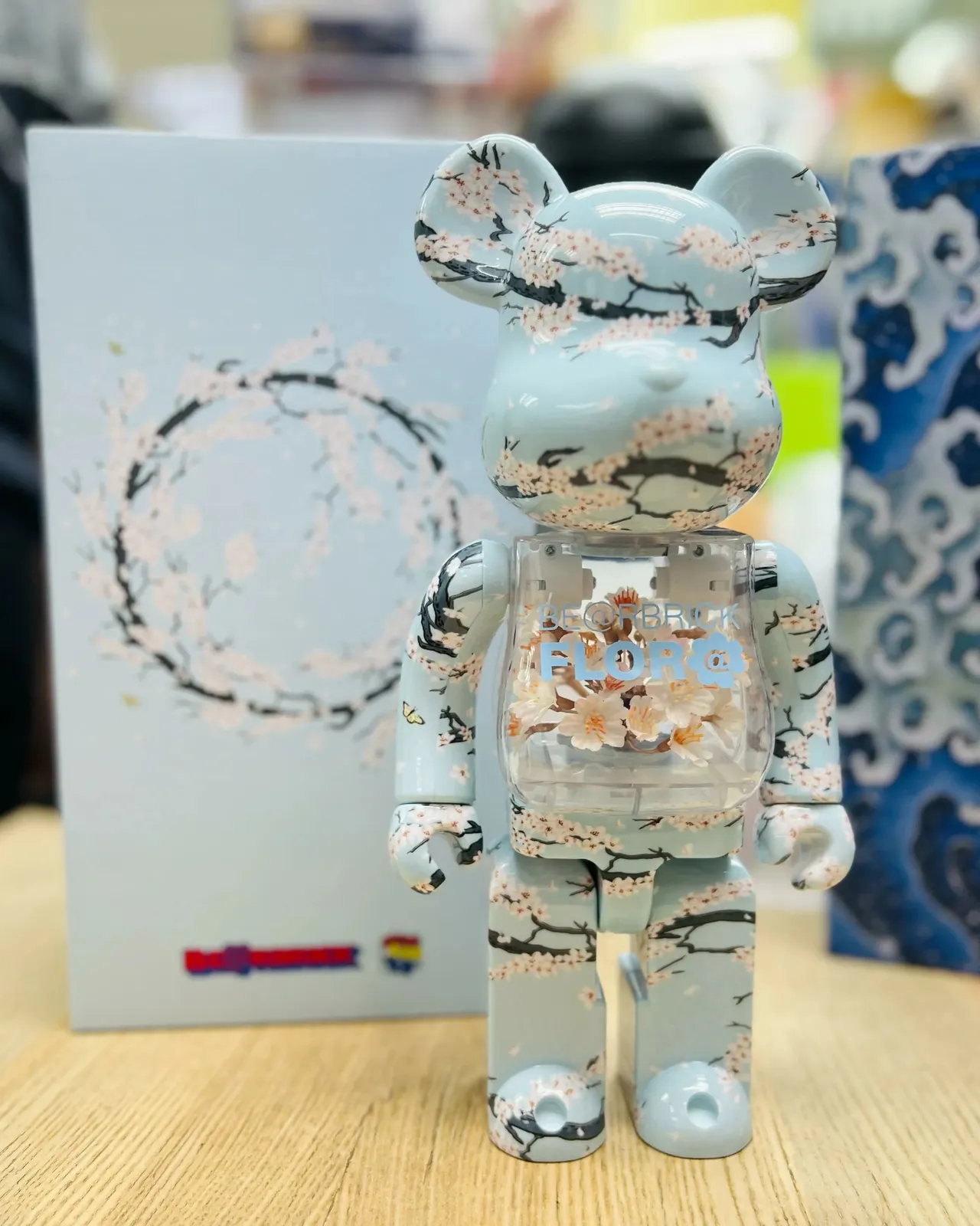 Figurine Bearbrick 400% avec un design Flora Sakura, motifs de fleurs de cerisier sur fond clair, objet de collection