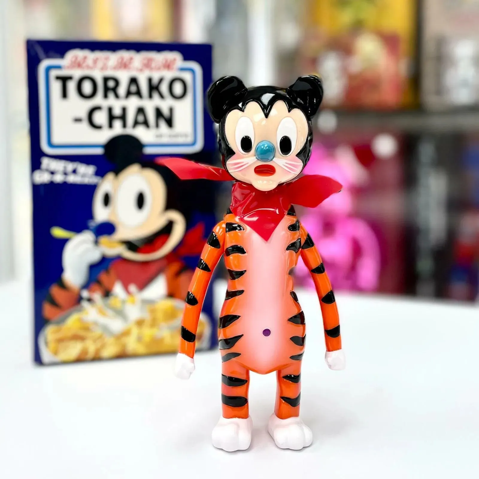 Torako The Tiger Vinylfigur, ein stilisierter anthropomorpher Tiger, stehend auf hellem Hintergrund.