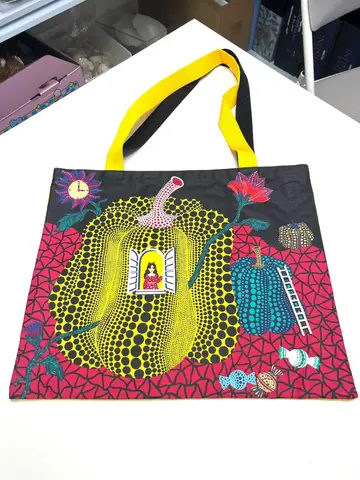 Bolso tote blanco YAYOI KUSAMA « Hello » con un gran punto rojo central rodeado de puntos más pequeños, y la palabra « Hello
