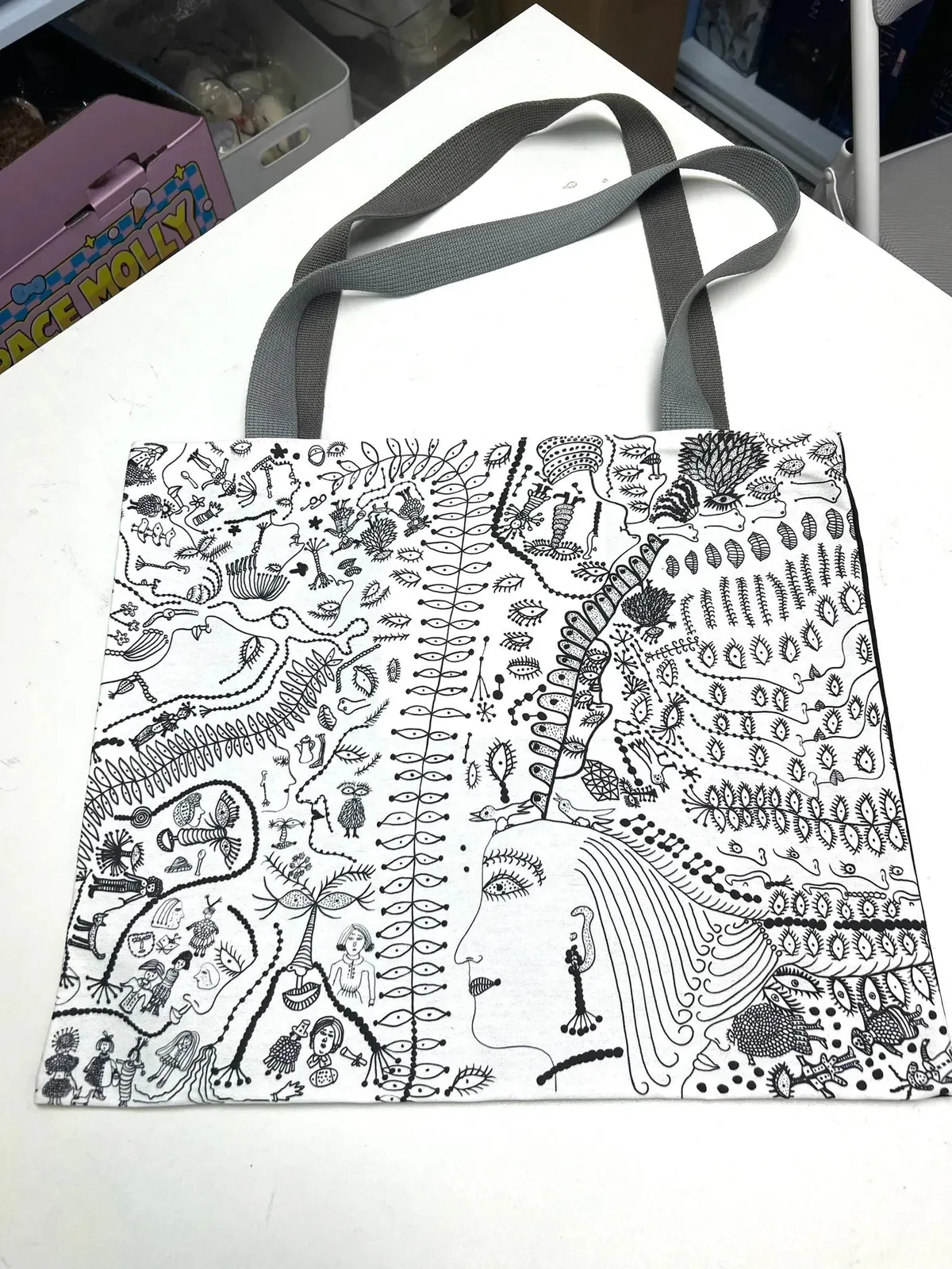 Bolso tote 'Love Forever' de Yayoi Kusama con patrones repetitivos, colocado sobre una superficie neutra.