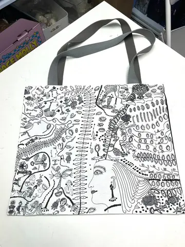 Bolso tote 'Love Forever' de Yayoi Kusama con patrones repetitivos, colocado sobre una superficie neutra.