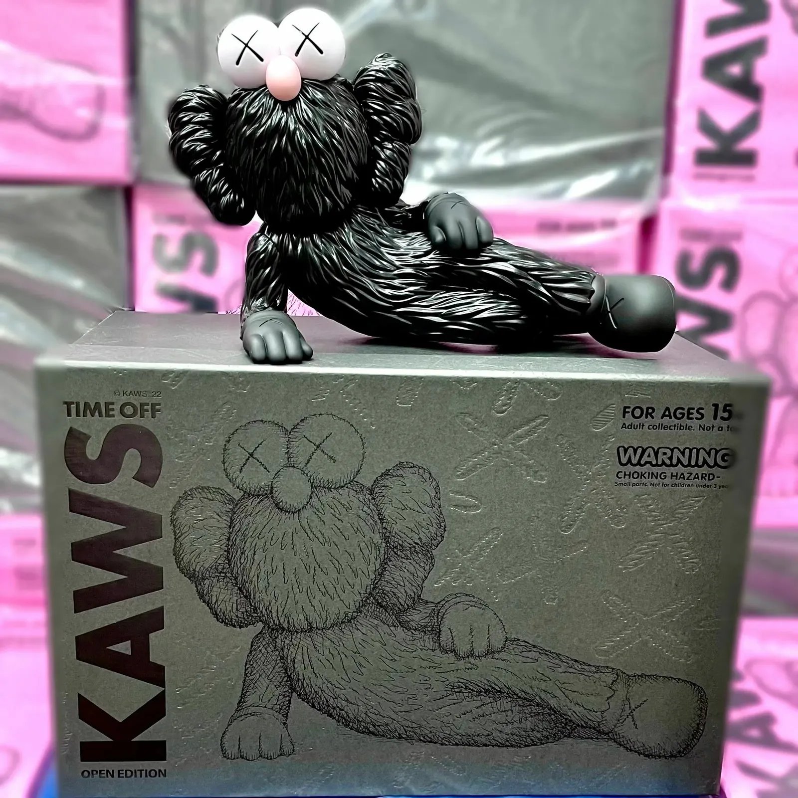 Art toy KAWS TIME OFF en color negro, una figura estilizada sentada con las manos cruzadas